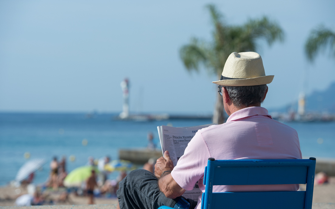 Cannes, 16.09.2014: Ein Mann an der Strandpromenade in Cannes liest seine Zeitung ©dpa